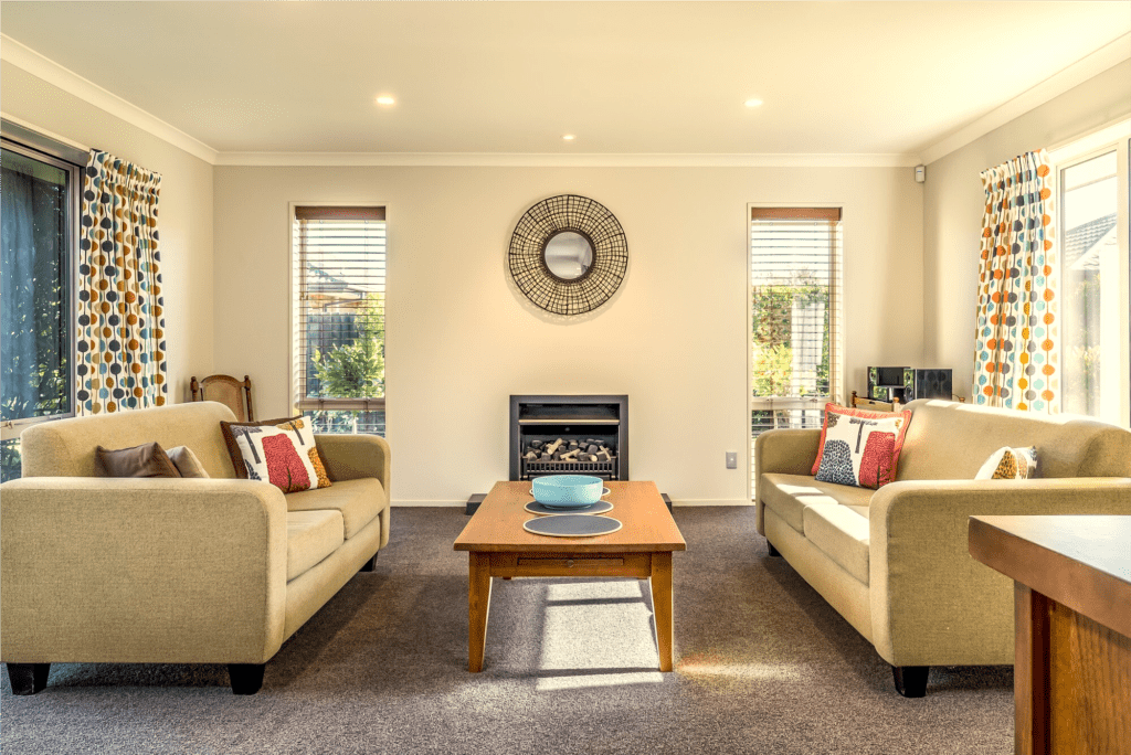 "Cozy living room with two couches, coffee table, and elegant curtain design, highlighting neweradecors and interior design in Delhi."