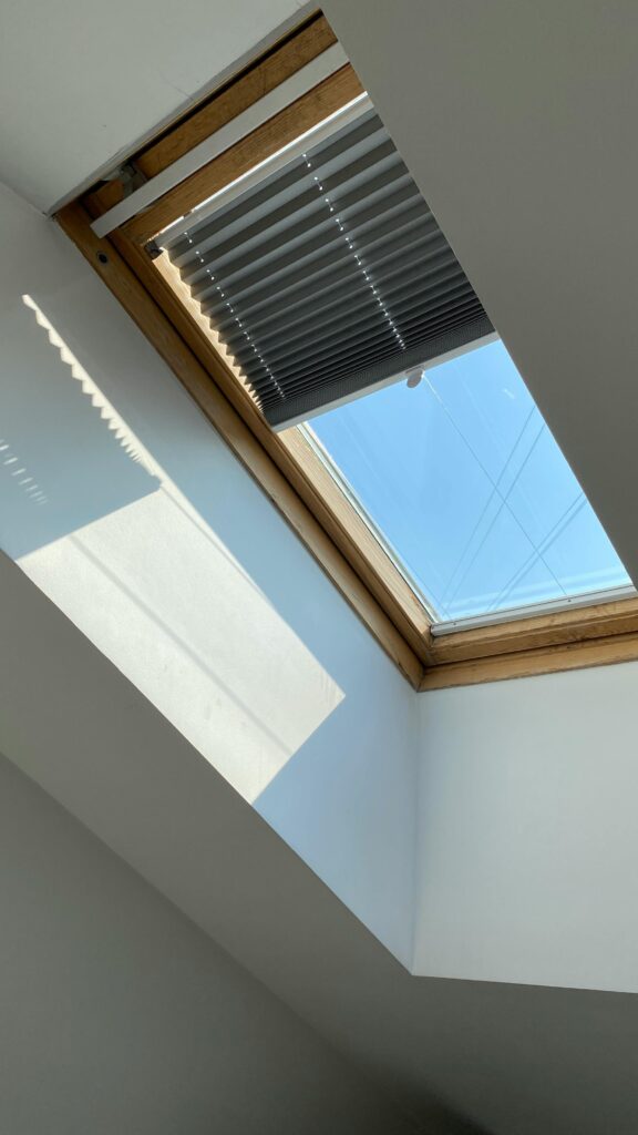 A well-lit space with a skylight and chic blinds, exemplifying sophisticated interior design in Delhi.