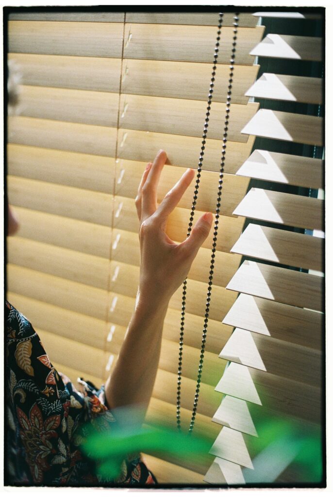 A person gazes thoughtfully out a window, reflecting the essence of interior design in Delhi.