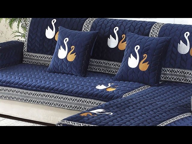 A blue couch adorned with a quilted cover, showcasing stylish interior design in Delhi, complemented by elegant cushions.